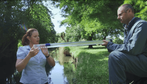 Photograph of clear tube being held by persons at each end (PNG file, 0.93 MB). 